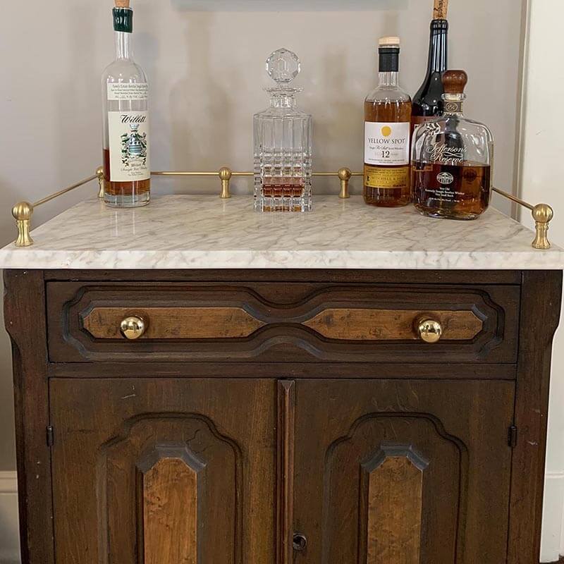 Antique cabinet with decorative brass gallery rail makes a great bar - Paxton hardware